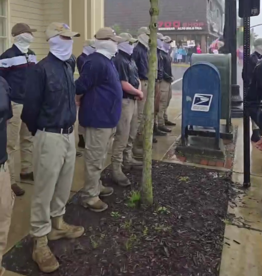 Patriot Front members standing stoic in the rain. Based.